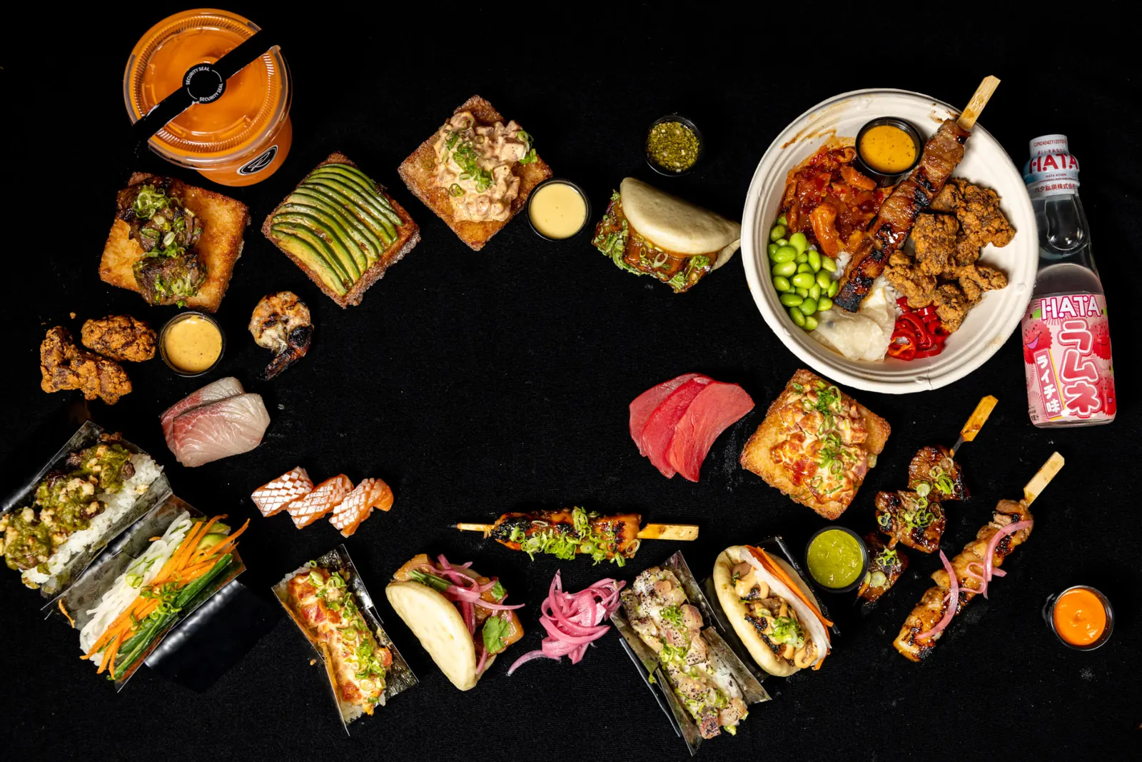 Overhead spread of Rollin bao buns, hand rolls, crispy rice and robata skewers